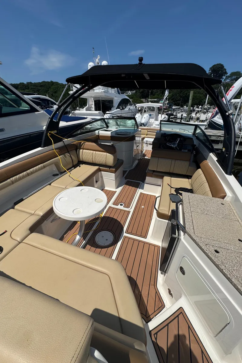 Slide: The Image of 2015 Sea Ray 290 Sundeck boat interior with tan seating and wood flooring. - 15