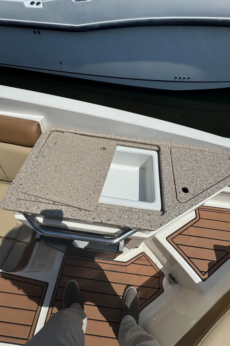 Slide: The Image of 2015 Sea Ray 290 Sundeck boat with a built-in countertop and storage compartment. - 17