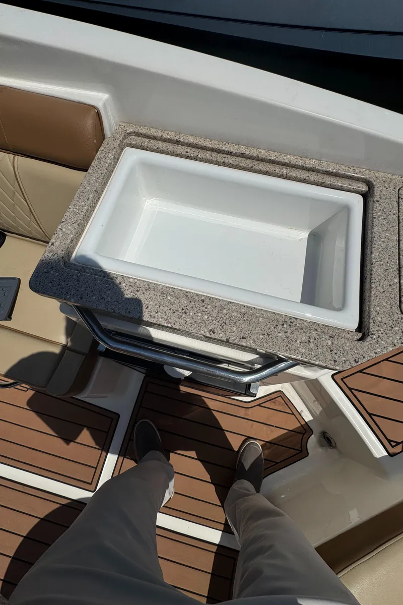 Slide: The Image of 2015 Sea Ray 290 Sundeck interior with built-in cooler and teak flooring. - 18