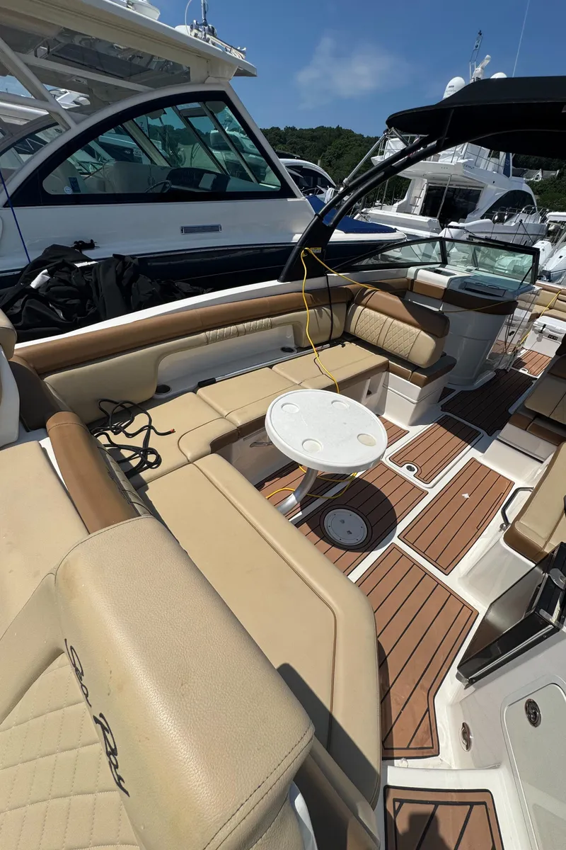 Slide: The Image of 2015 Sea Ray 290 Sundeck interior with beige seating and wooden flooring. - 19