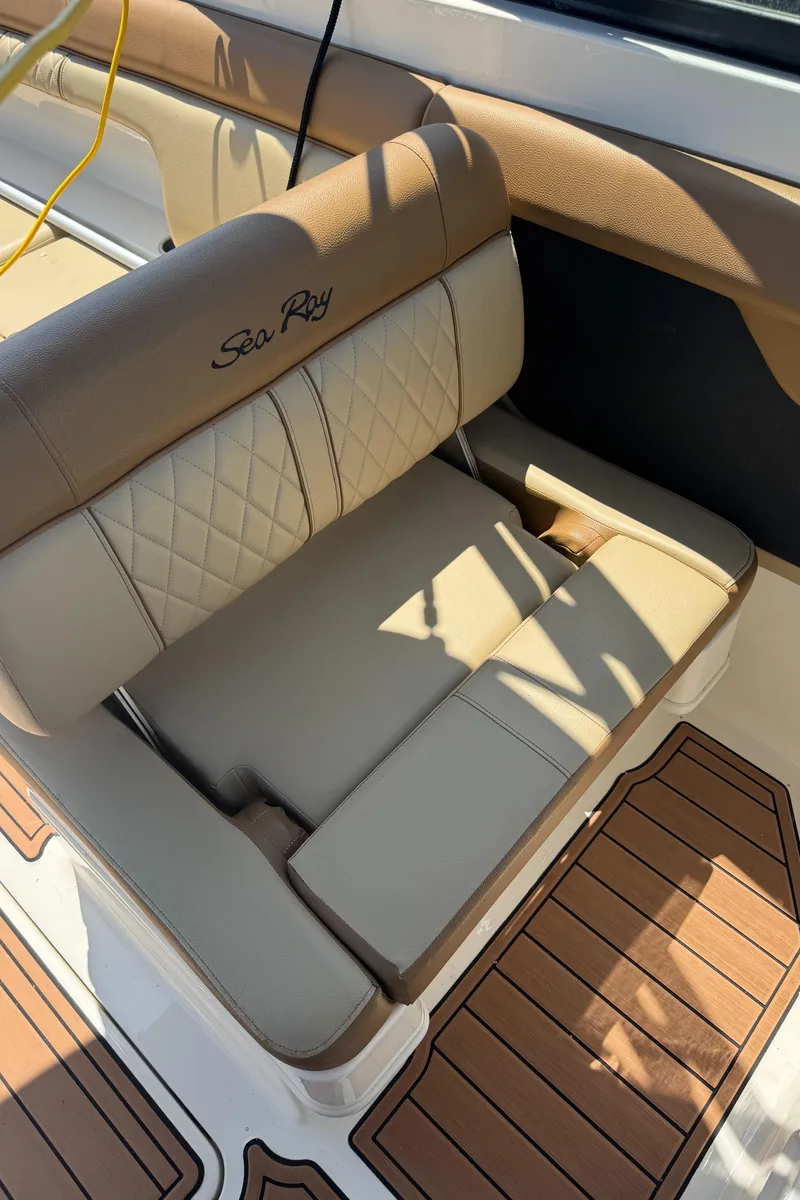 Slide: The Image of 2015 Sea Ray 290 Sundeck boat seat with tan upholstery and wood-patterned flooring. - 24