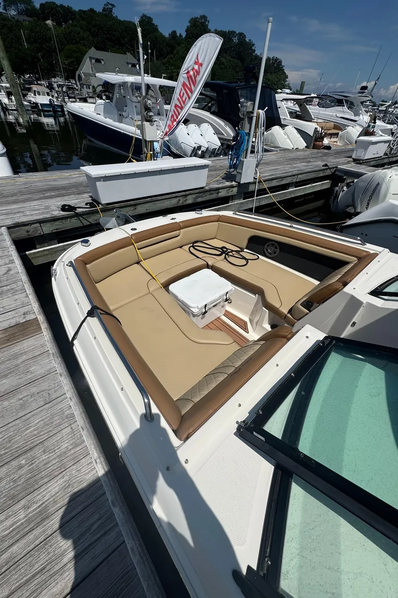 Slide: The Image of 2015 Sea Ray 290 Sundeck boat docked, featuring spacious seating and a cooler on deck. - 3