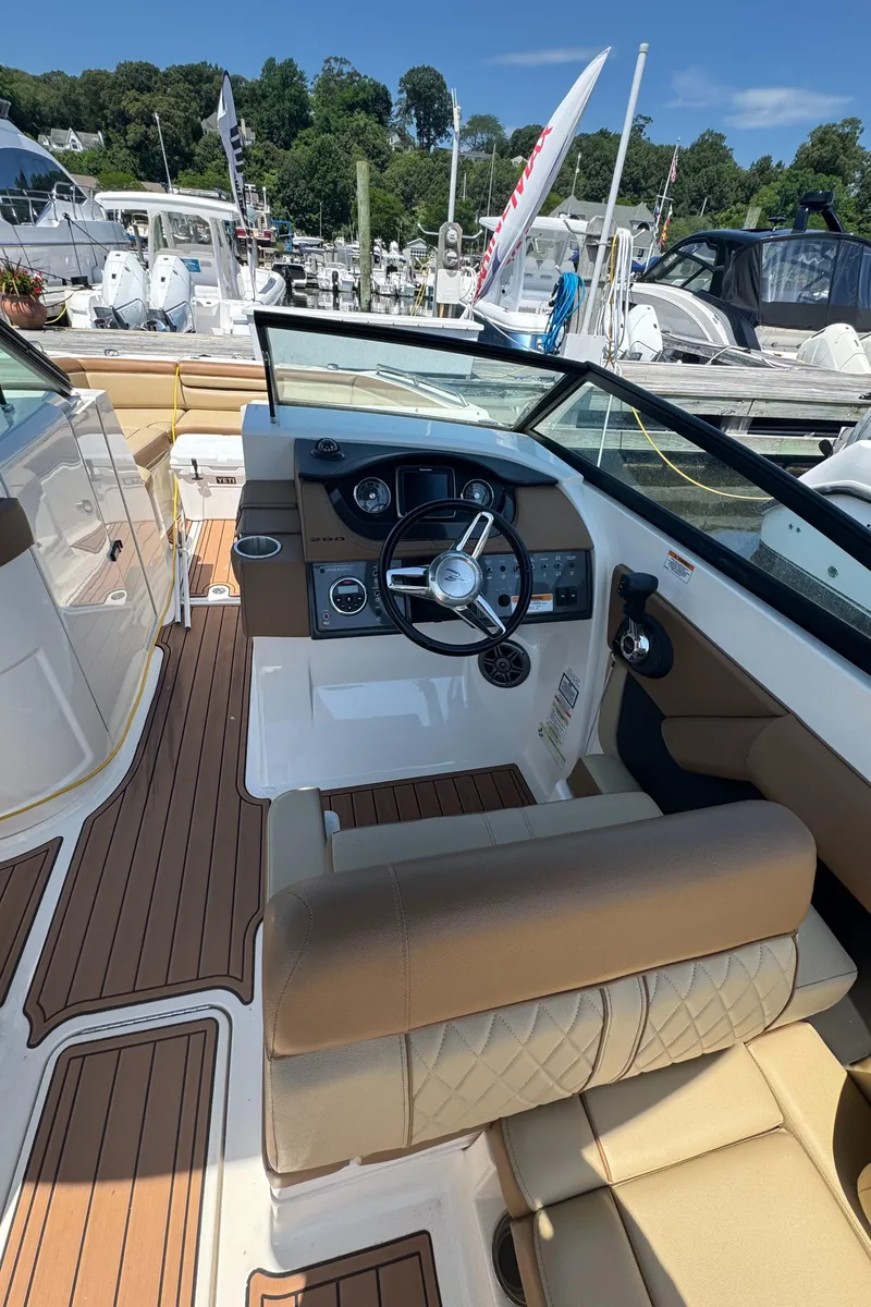 Slide: The Image of 2015 Sea Ray 290 Sundeck boat interior with helm, steering wheel, and seating. - 4