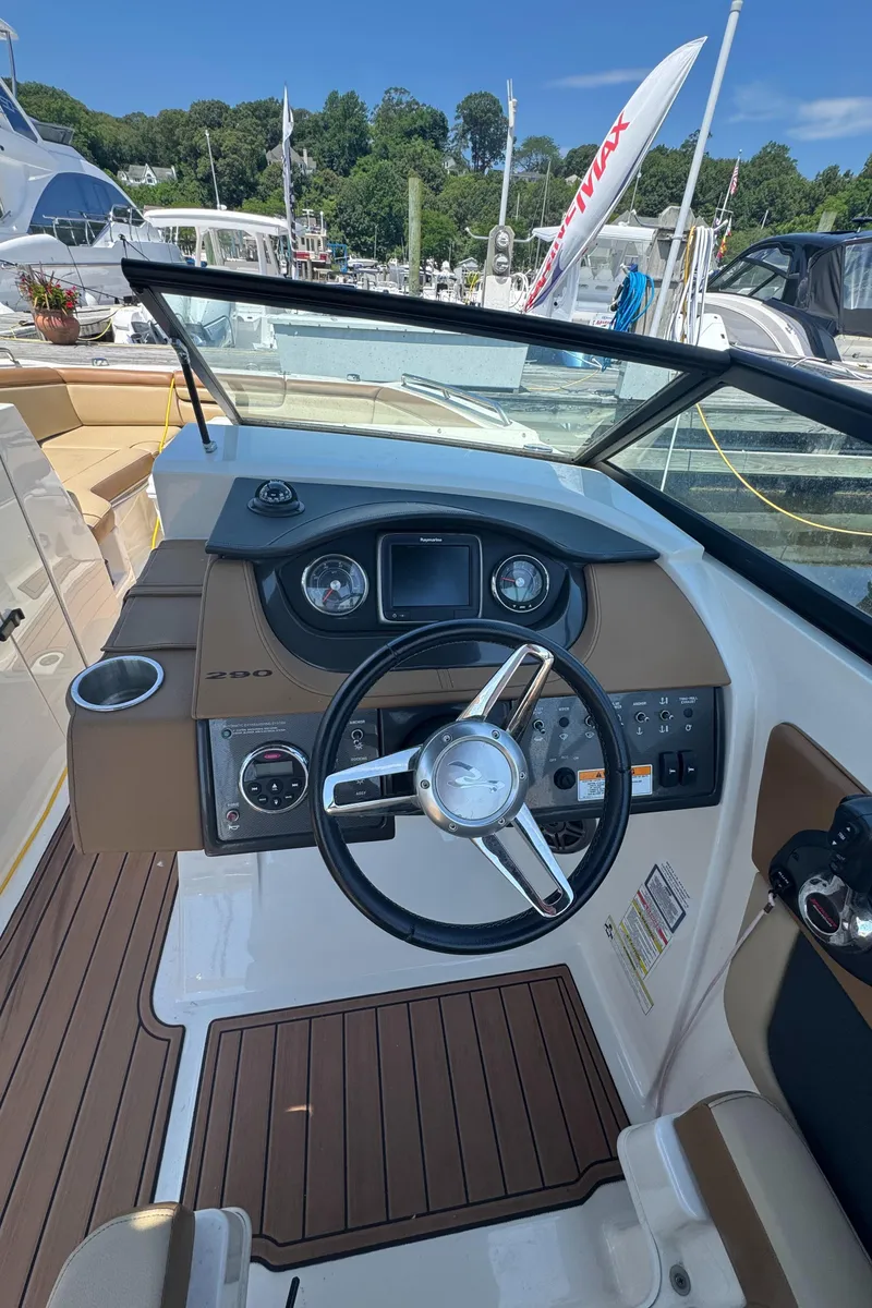 Slide: The Image of 2015 Sea Ray 290 Sundeck helm with steering wheel and control panel at marina. - 5