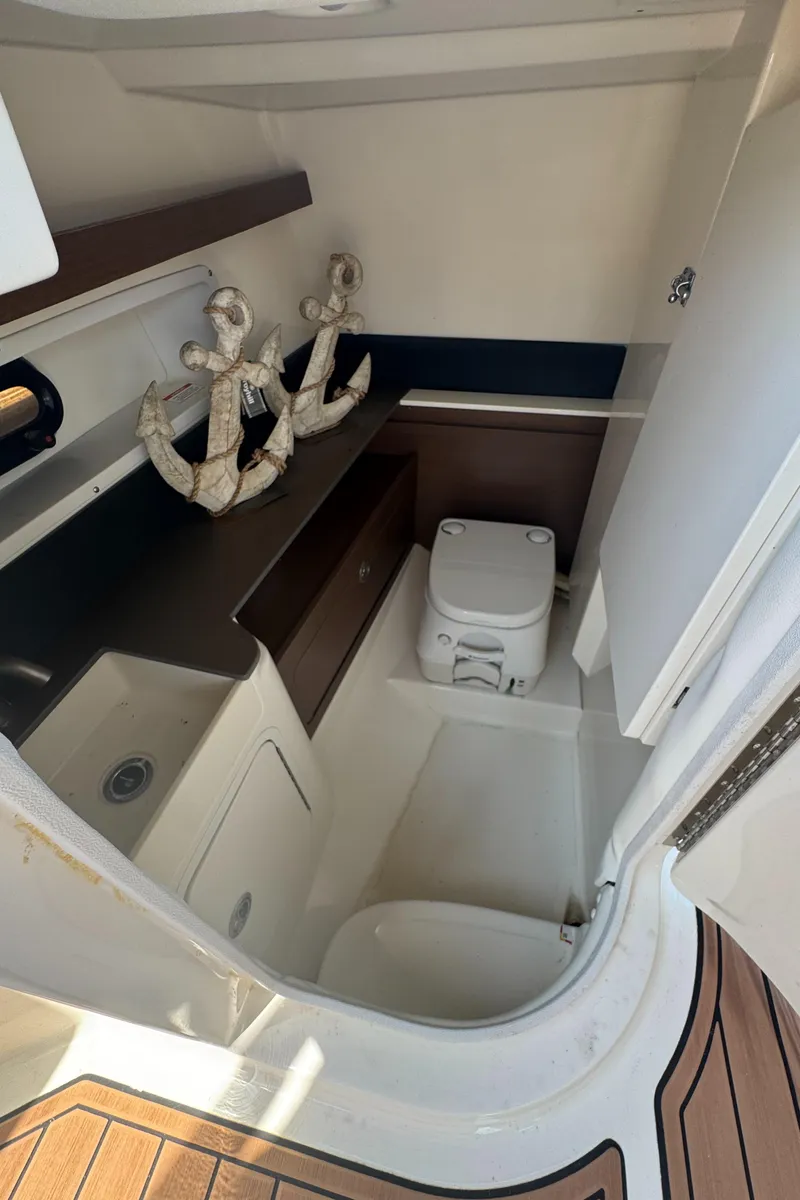 Slide: The Image of 2015 Sea Ray 290 Sundeck interior with nautical decor and compact bathroom amenities. - 6