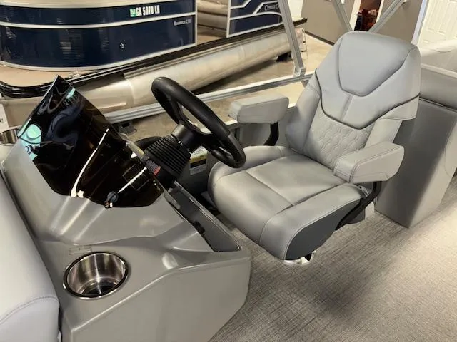 Slide: The Image of 2025 Tahoe Pontoon SLT 2180 QL captain's chair and steering console in a showroom. - 12