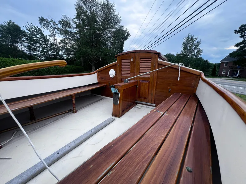 Slide: The Image of Wooden interior of a 2007 Arey's Pond 16 sailboat with benches and storage. - 12