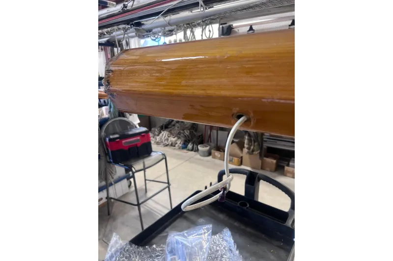 Slide: The Image of Wooden mast of a 2007 Arey's Pond 16 sailboat in a workshop setting. - 25
