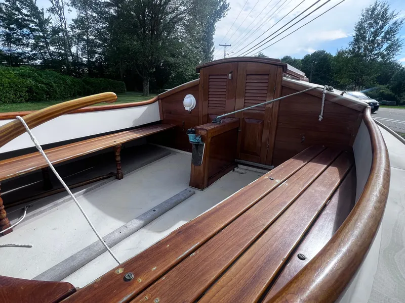 Slide: The Image of Wooden interior of a 2007 Arey's Pond 16 sailboat with benches and storage. - 6