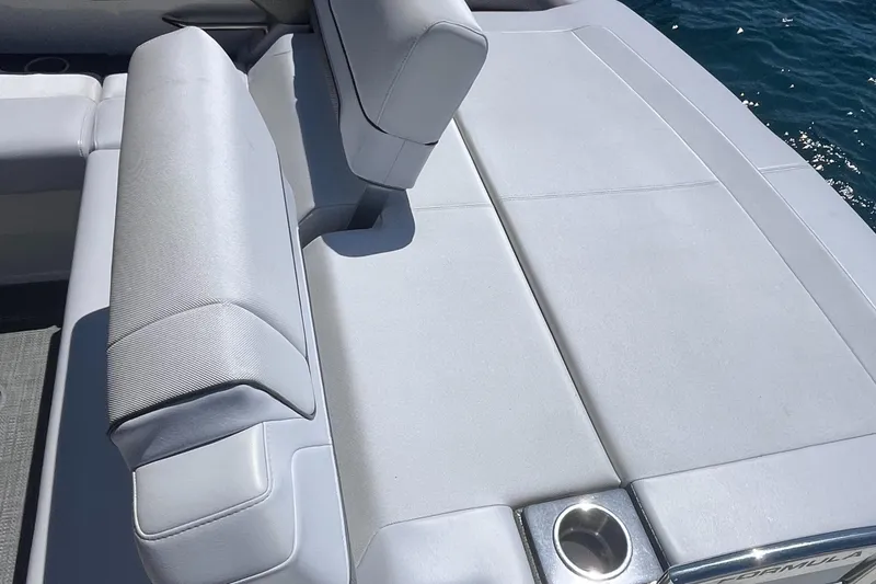 Slide: The Image of 2016 Formula 310 SS boat interior with gray seating and cup holder, near water. - 16