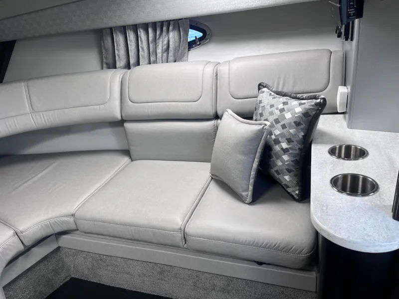 Slide: The Image of 2016 Formula 310 SS interior with gray seating, decorative pillows, and cup holders. - 18