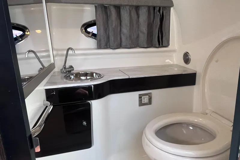 Slide: The Image of 2016 Formula 310 SS boat bathroom with sink, mirror, and toilet. - 25