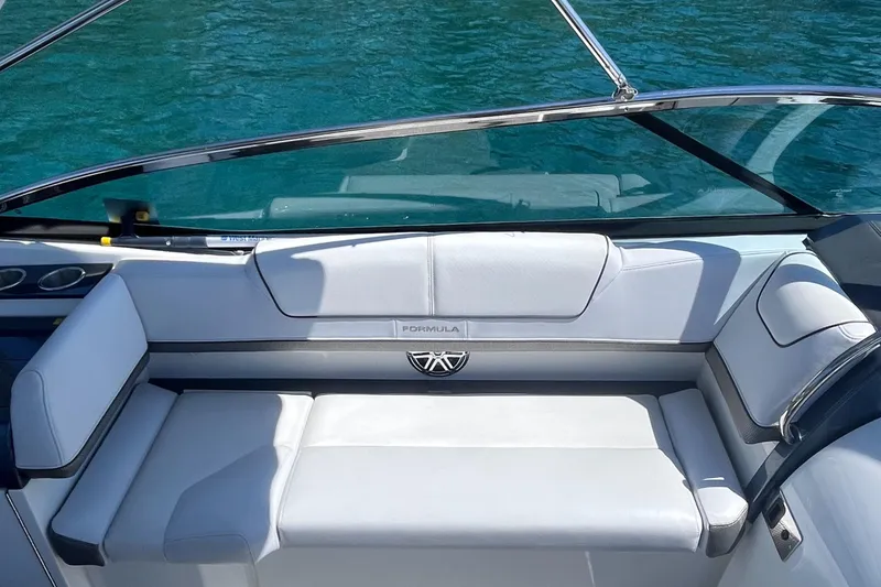 Slide: The Image of 2016 Formula 310 SS boat interior with white seating and clear blue water background. - 9