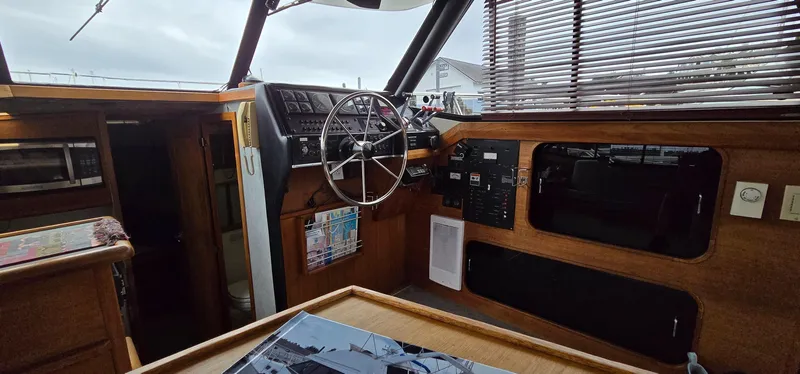 Slide: The Image of 1991 Bayliner 3288 Motoryacht interior with steering wheel, control panel, and wooden accents. - 18