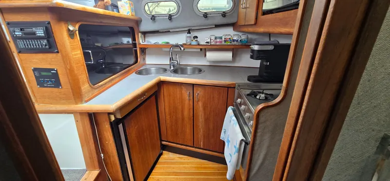 Slide: The Image of 1991 Bayliner 3288 Motoryacht kitchen with wood cabinetry, dual sinks, stove, and appliances. - 23