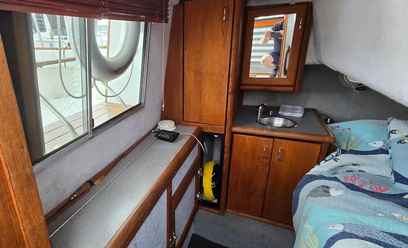 Slide: The Image of 1991 Bayliner 3288 Motoryacht cabin interior with wood cabinetry and nautical-themed bedding. - 27