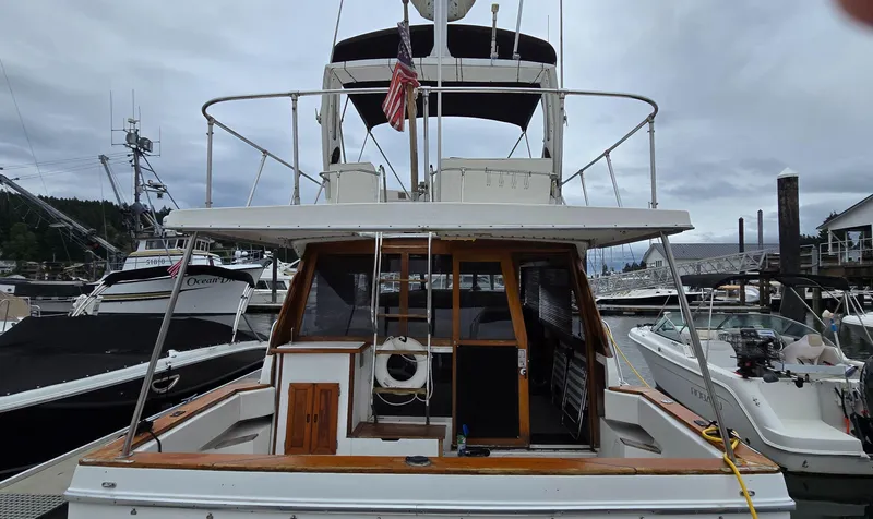 Slide: The Image of 1991 Bayliner 3288 Motoryacht docked at marina, rear view with American flag. - 3