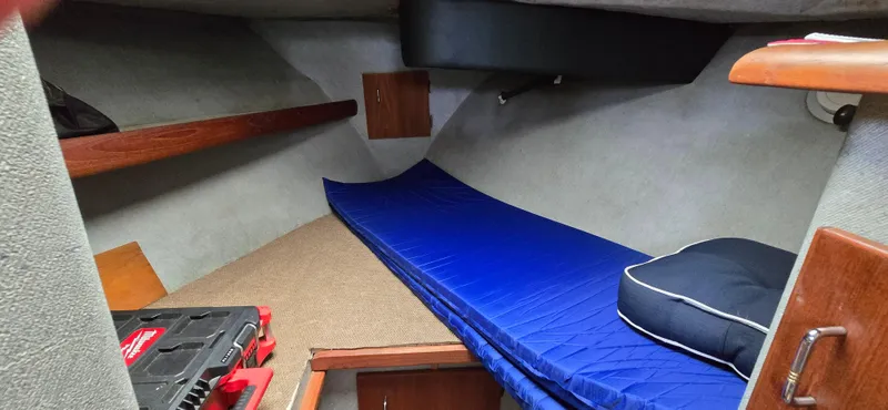 Slide: The Image of 1991 Bayliner 3288 Motoryacht cabin interior with blue mattress and storage compartments. - 31