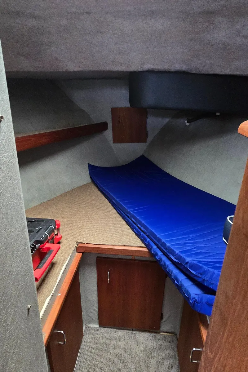 Slide: The Image of 1991 Bayliner 3288 Motoryacht cabin interior with blue mattress and wooden storage. - 32