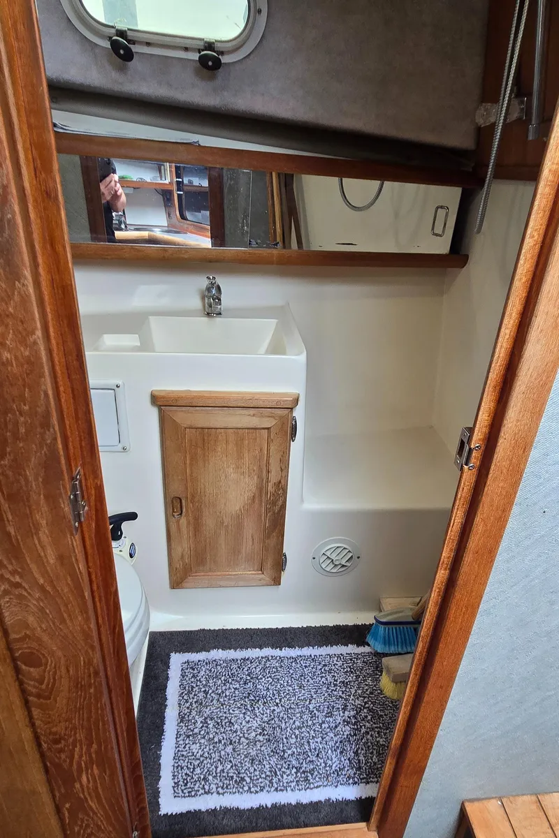 Slide: The Image of 1991 Bayliner 3288 Motoryacht bathroom with sink, mirror, and wooden cabinet. - 34
