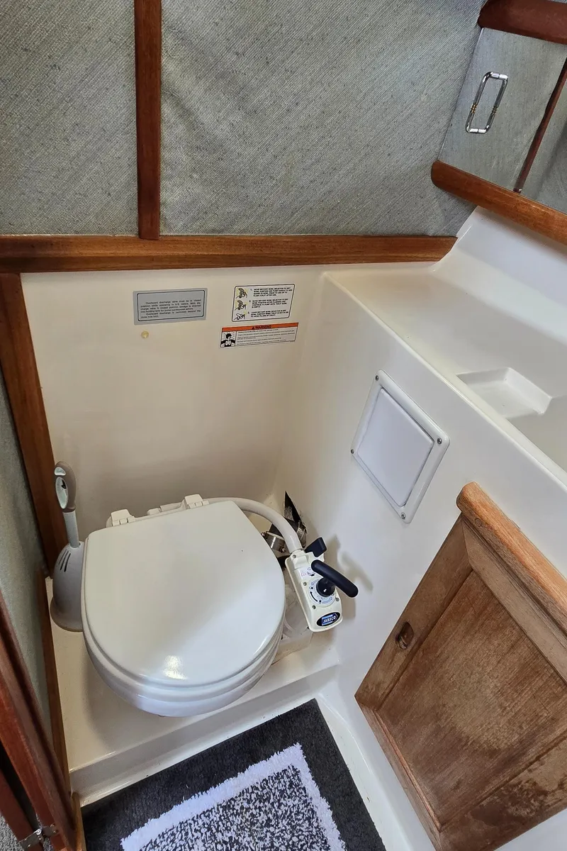 Slide: The Image of 1991 Bayliner 3288 Motoryacht bathroom with marine toilet and wooden cabinetry. - 36