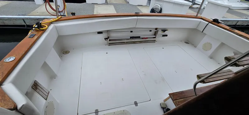 Slide: The Image of 1991 Bayliner 3288 Motoryacht cockpit with wooden trim and storage compartments at a marina. - 6