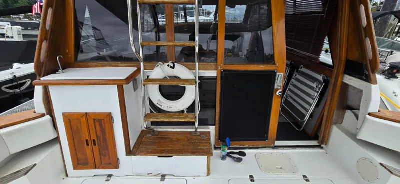 Slide: The Image of 1991 Bayliner 3288 Motoryacht deck with wooden ladder, life preserver, and storage cabinet. - 7