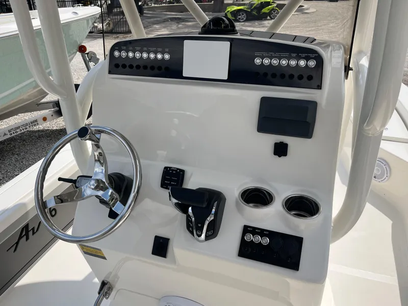 Slide: The Image of Control panel of 2026 Avenger AV26 boat with steering wheel and switches. - 16