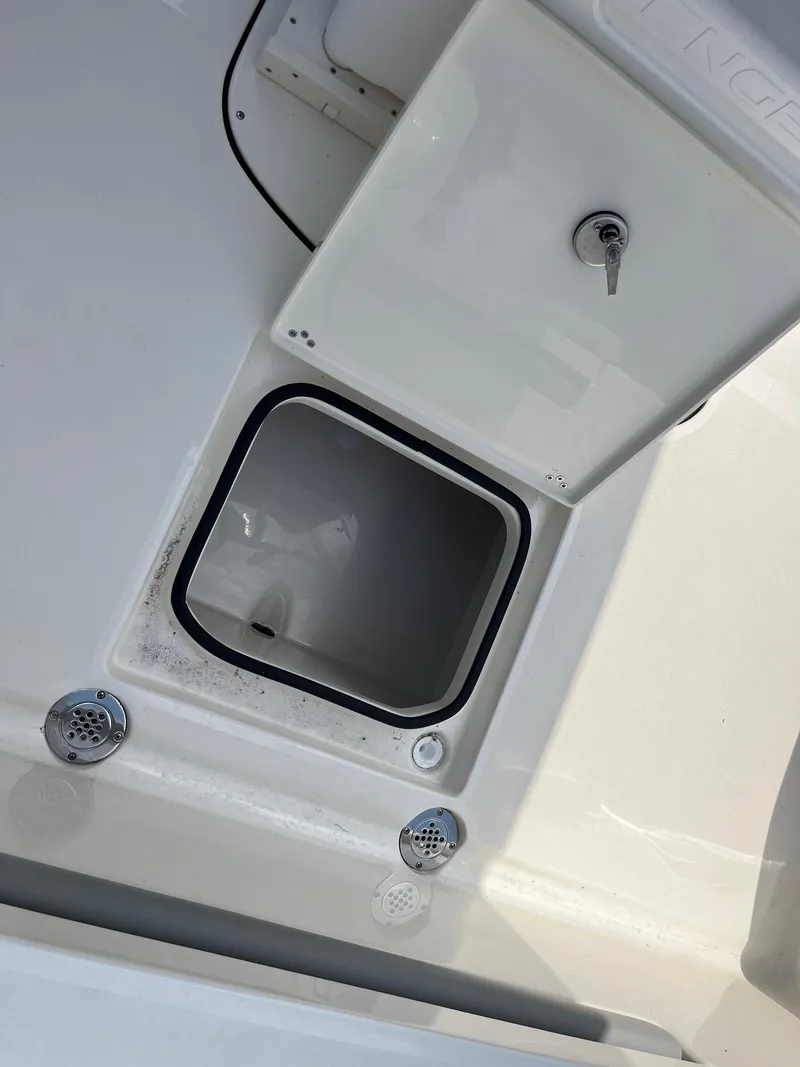 Slide: The Image of Open storage compartment on 2026 Avenger AV26 boat with key lock and drainage features. - 24