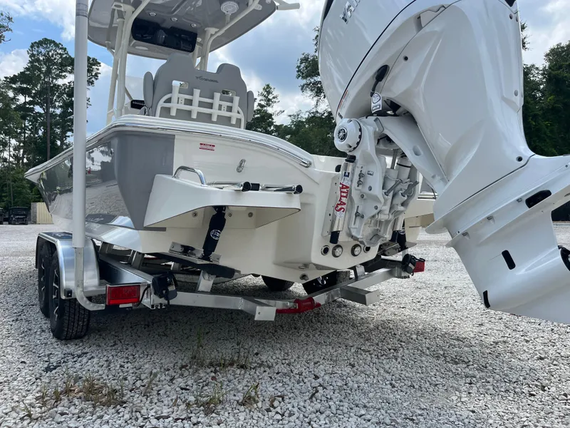 Slide: The Image of 2026 Avenger AV26 boat on trailer, featuring powerful outboard motor, parked on gravel. - 32