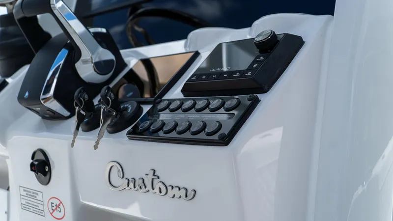 Slide: The Image of 2026 Tidewater 2700 Carolina Bay boat dashboard with controls and custom branding. - 18