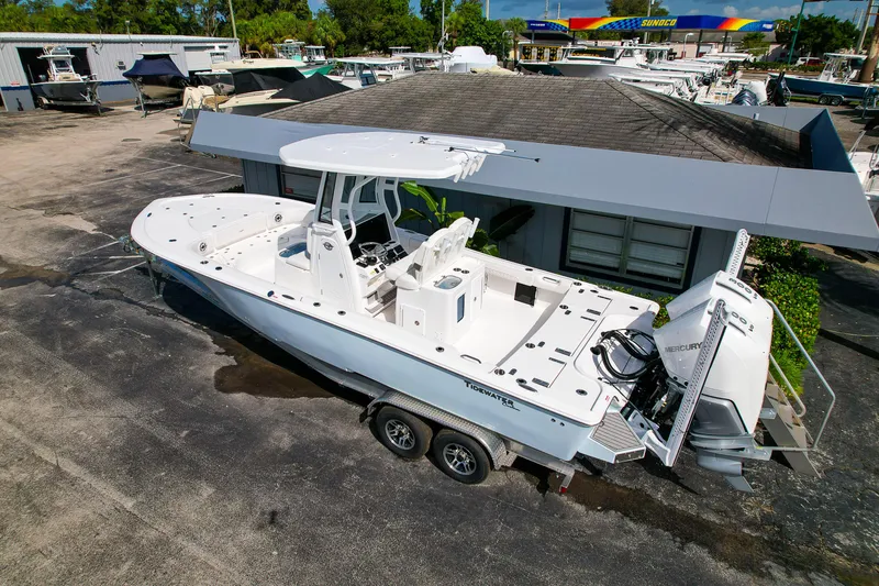 Slide: The Image of 2026 Tidewater 2700 Carolina Bay boat on trailer, parked at a marina. - 2
