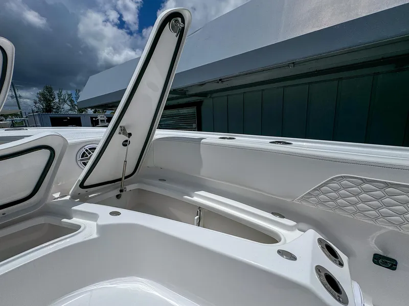 Slide: The Image of Open storage compartments on a 2026 Tidewater 2700 Carolina Bay boat under a cloudy sky. - 27