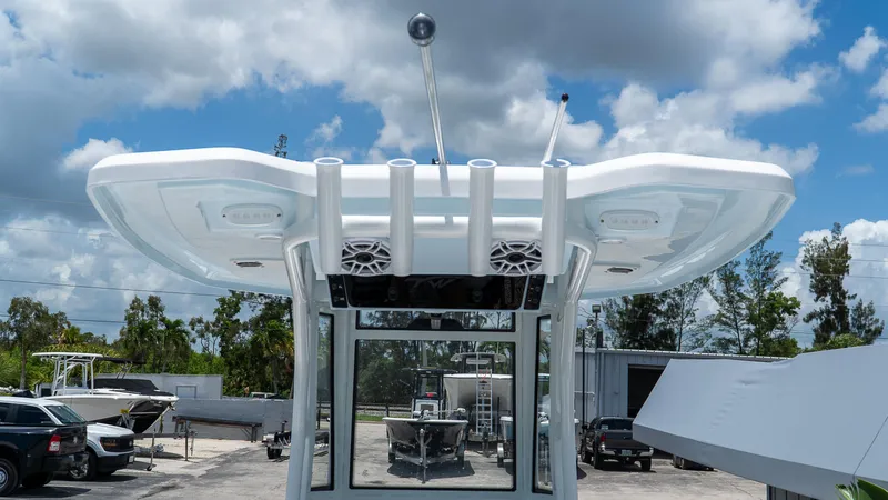Slide: The Image of 2026 Tidewater 2700 Carolina Bay boat with T-top and speakers, parked outdoors under cloudy sky. - 9