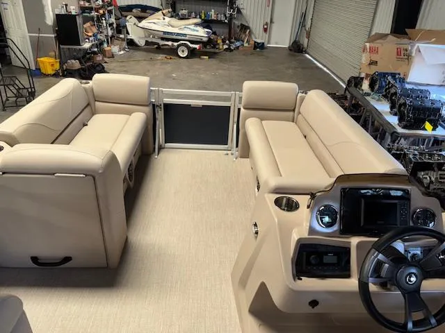 Slide: The Image of 2025 Tahoe Pontoon STX 1980 CR interior with beige seating and steering console in a garage. - 16