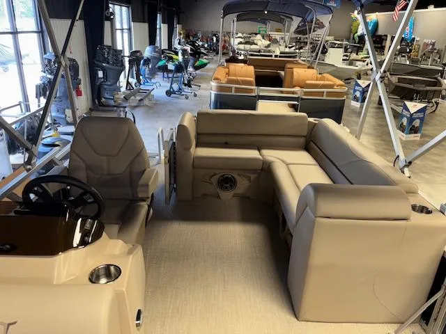 Slide: The Image of 2025 Tahoe Pontoon STX 1980 CR interior with beige seating in showroom. - 17
