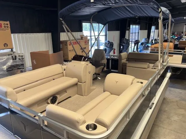 Slide: The Image of 2025 Tahoe Pontoon STX 1980 CR with beige seating and canopy in showroom. - 8