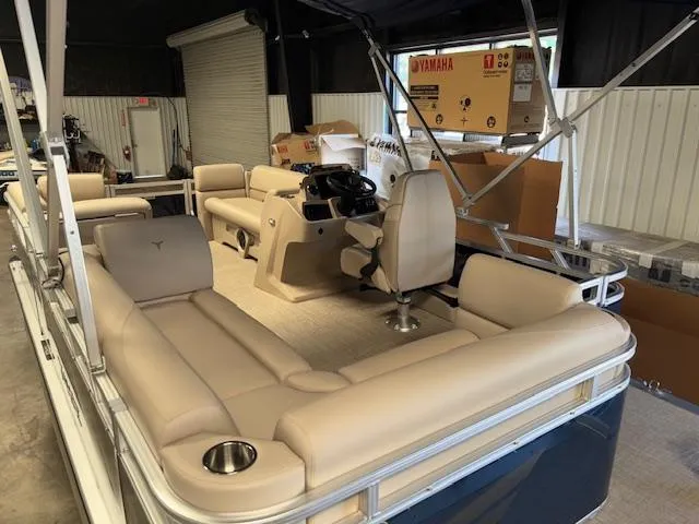 Slide: The Image of 2025 Tahoe Pontoon STX 1980 CR with beige seating and steering console in a showroom. - 9