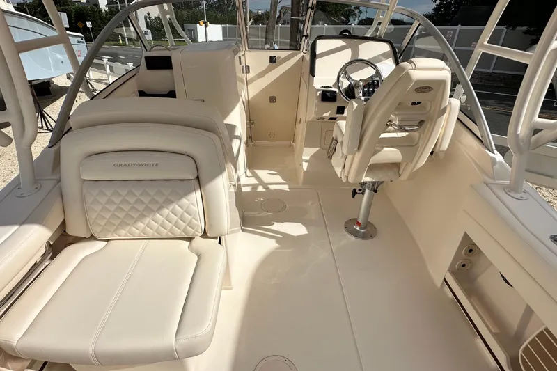 Slide: The Image of 2026 Grady-White Freedom 235 boat interior with luxurious seating and steering console. - 12