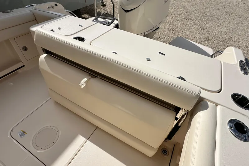 Slide: The Image of 2026 Grady-White Freedom 235 boat interior with beige seating and cup holders. - 6