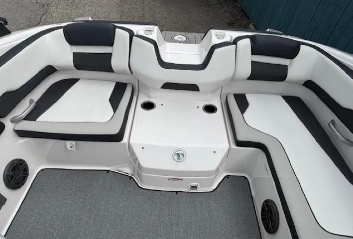 Slide: The Image of 2022 Yamaha AR195 boat interior with white and black seating, cup holders, and speakers. - 30