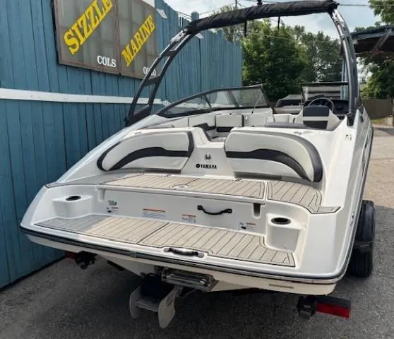 Slide: The Image of 2022 Yamaha AR195 boat with sleek design, parked near a blue building. - 5