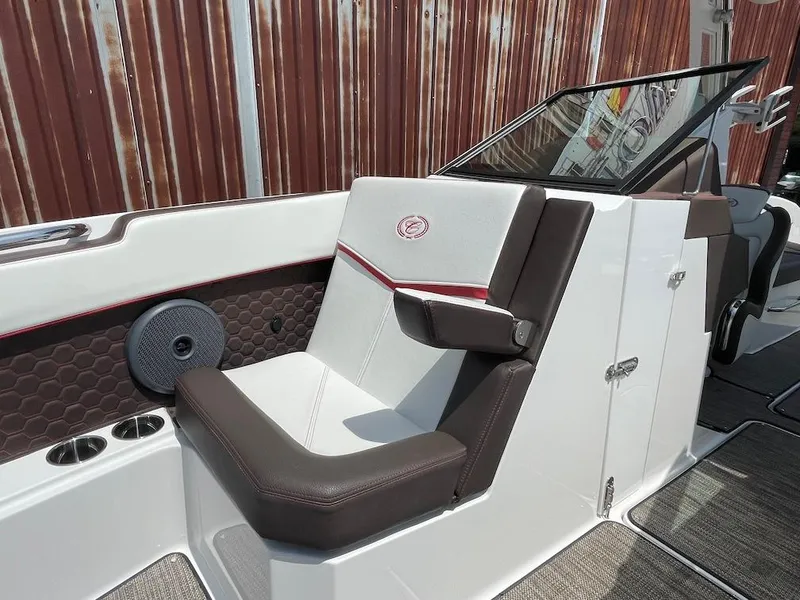 Slide: The Image of 2023 Cobalt R8 Surf boat interior with brown and white seating, speaker, and cup holders. - 12
