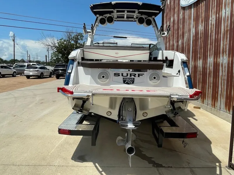 Slide: The Image of 2023 Cobalt R8 Surf boat, rear view, parked outdoors on a sunny day. - 3