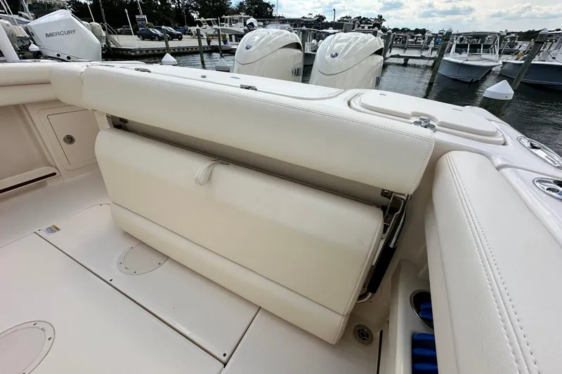 Slide: The Image of 2026 Grady-White Freedom 275 boat with foldable seating and dual outboard engines at marina. - 10