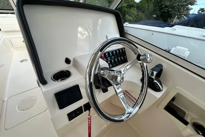 Slide: The Image of 2026 Grady-White Freedom 275 boat helm with steering wheel and control panel. - 17
