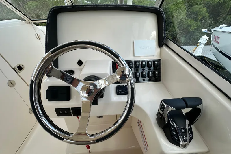 Slide: The Image of 2026 Grady-White Freedom 275 helm with steering wheel and control panel. - 18