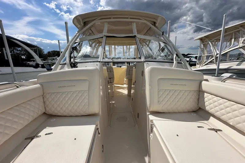 Slide: The Image of 2026 Grady-White Freedom 275 boat interior with cushioned seating and clear skies. - 23