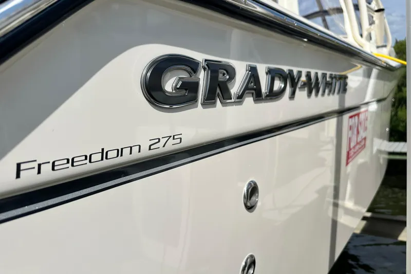 Slide: The Image of 2026 Grady-White Freedom 275 boat side view with logo and model name. - 5