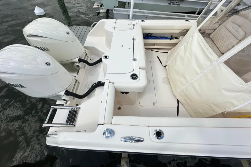 Slide: The Image of 2026 Grady-White Freedom 275 boat with dual Yamaha engines, docked at a marina. - 8